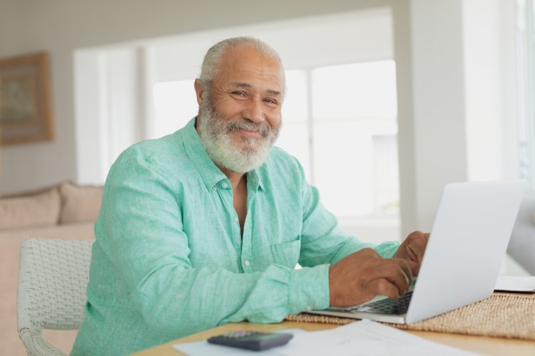 Smiling man in a green shirt with laptop